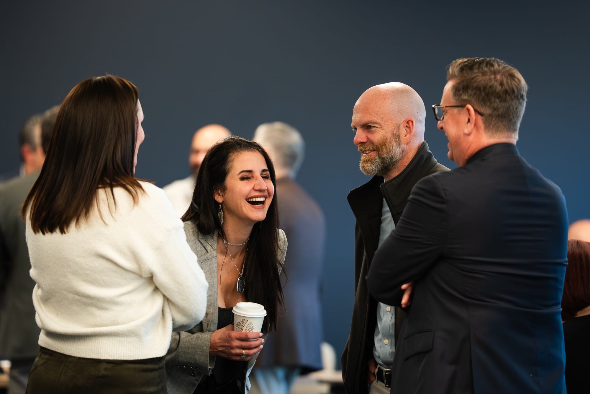 Executives laughing together during a break at a Collective event