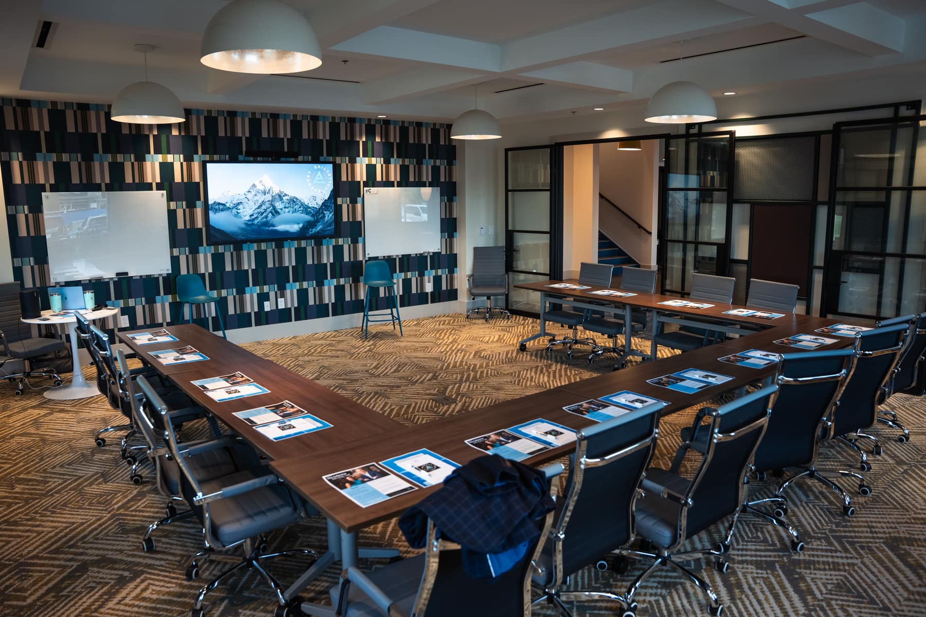 A meeting room set in a U shape with printed materials at every seat, ready for a leadership session