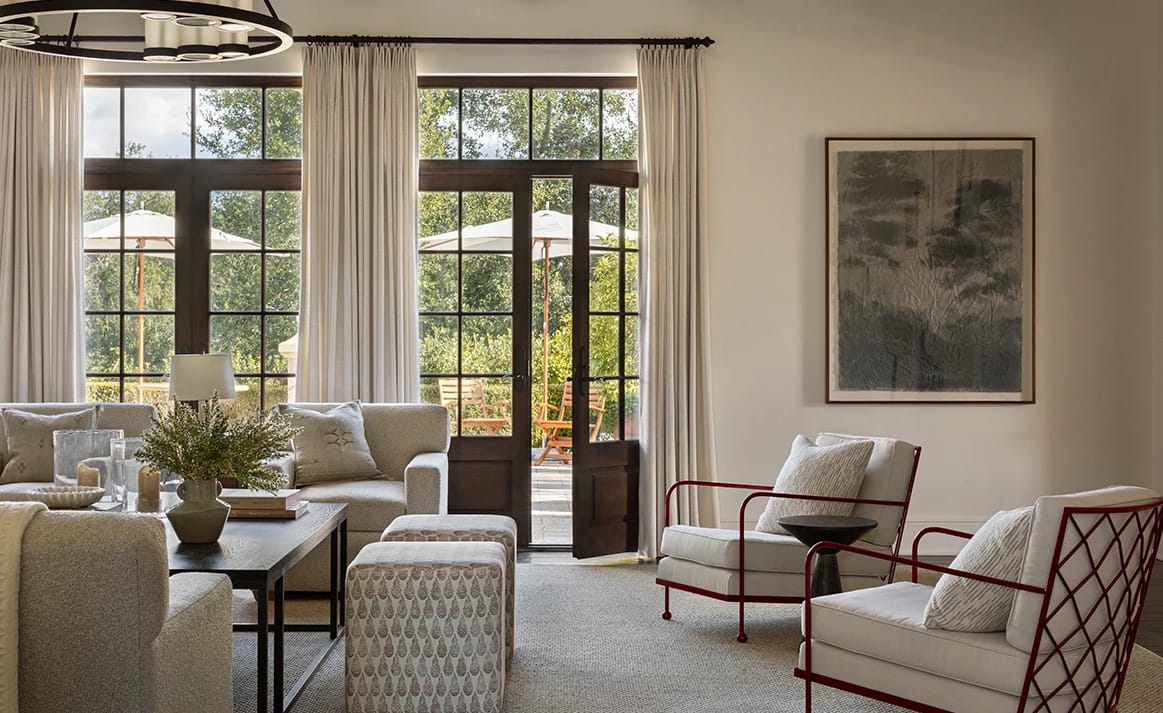 A bright living room with white sofas and garden doors
