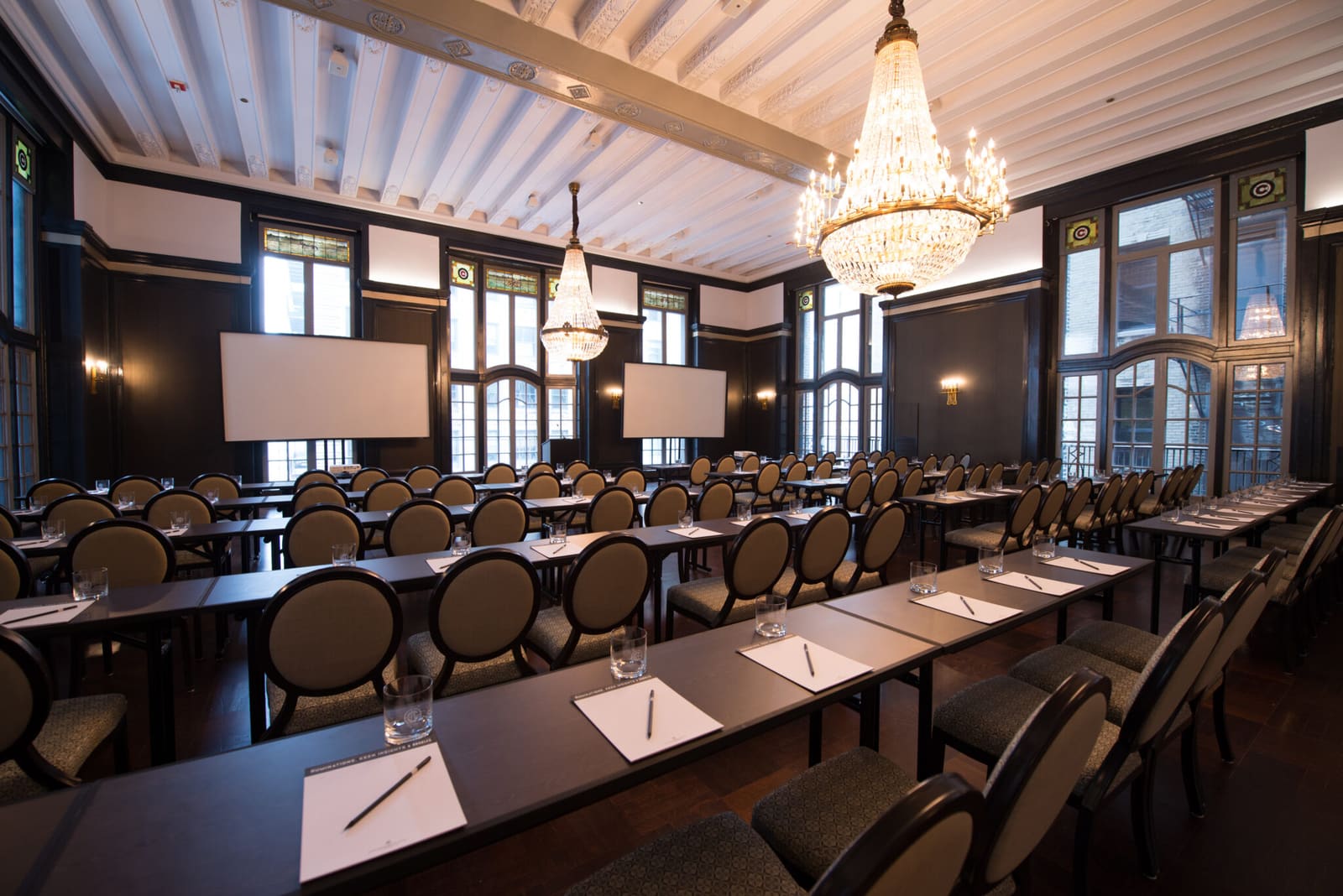Madison Ballroom set classroom style under crystal chandeliers and stained glass windows