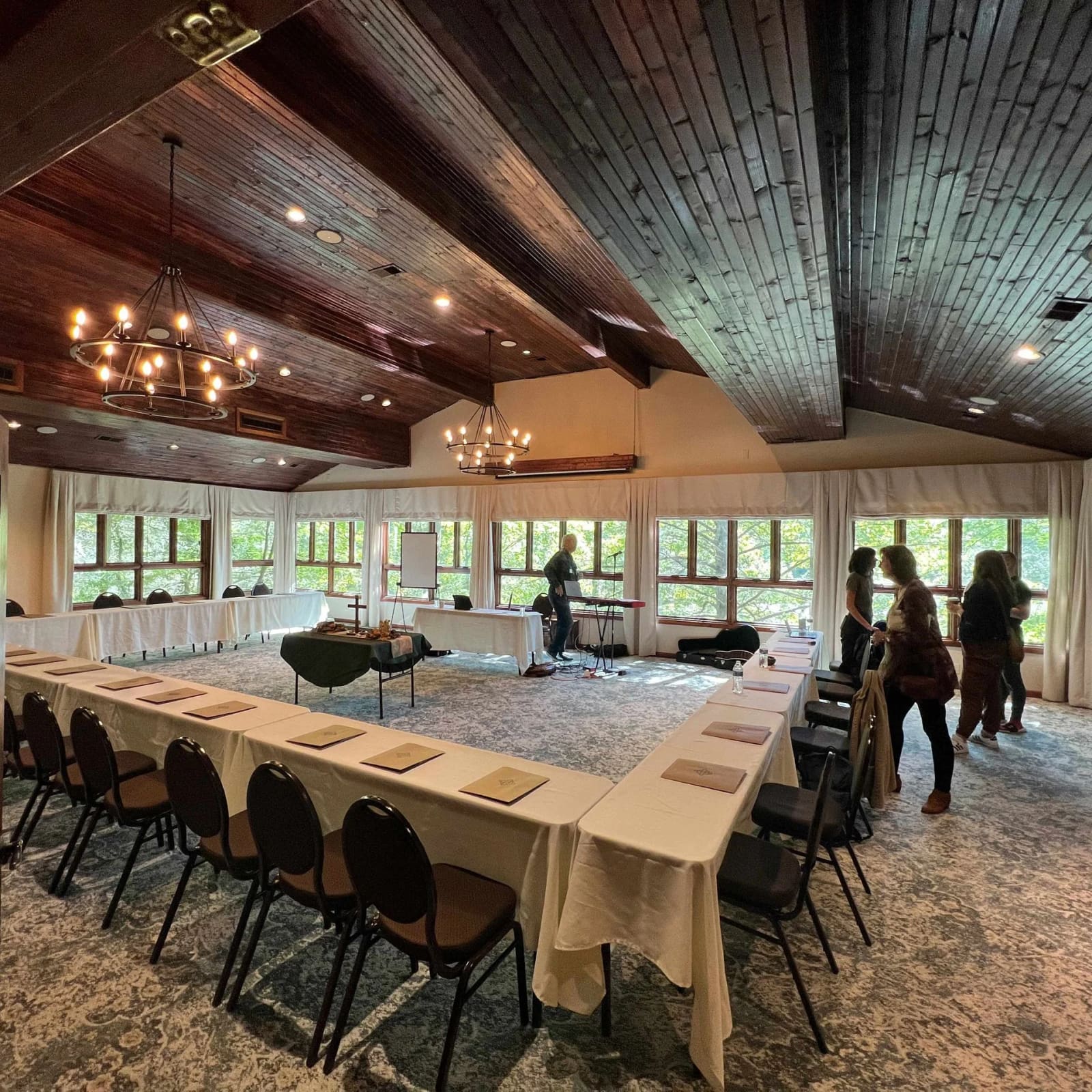 Wood-ceilinged meeting room set in a U shape with windows onto the trees