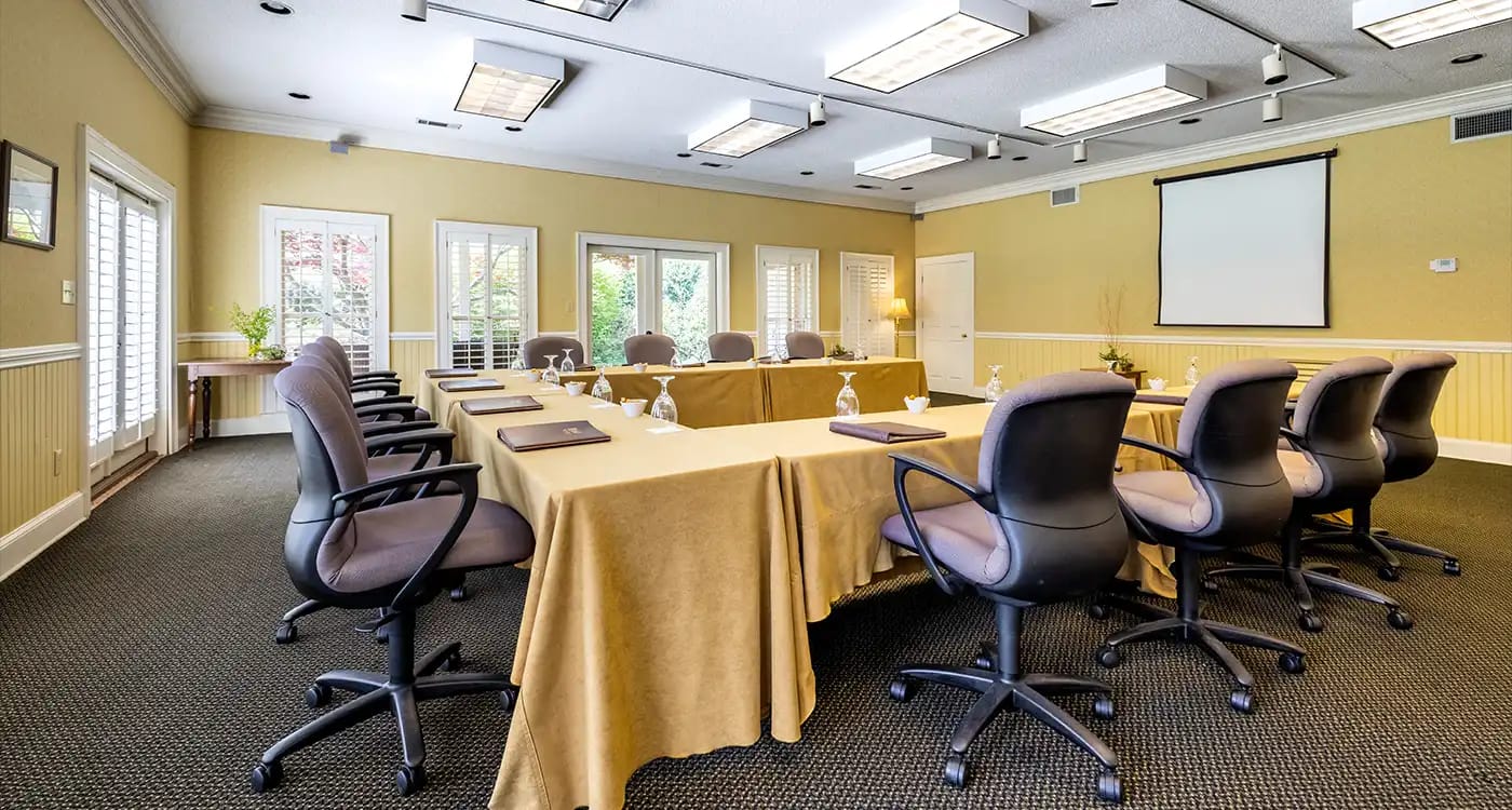 A small conference room with tables set for a meeting