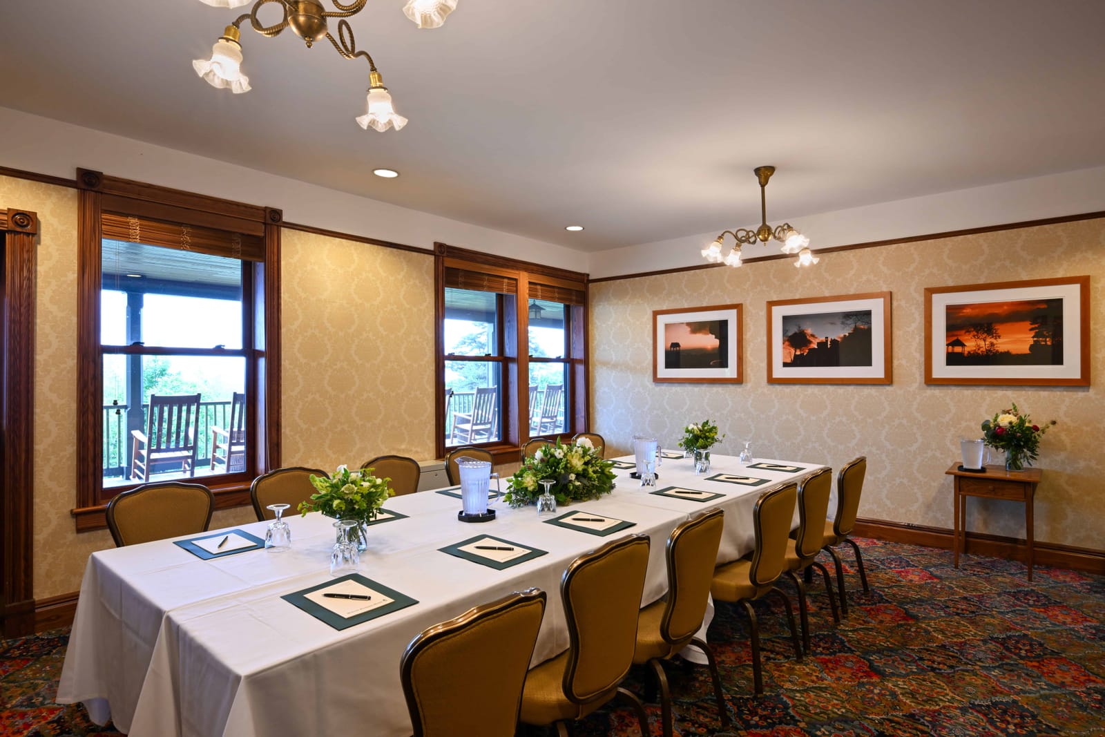 A long conference table set for a meeting beside windows facing the lake