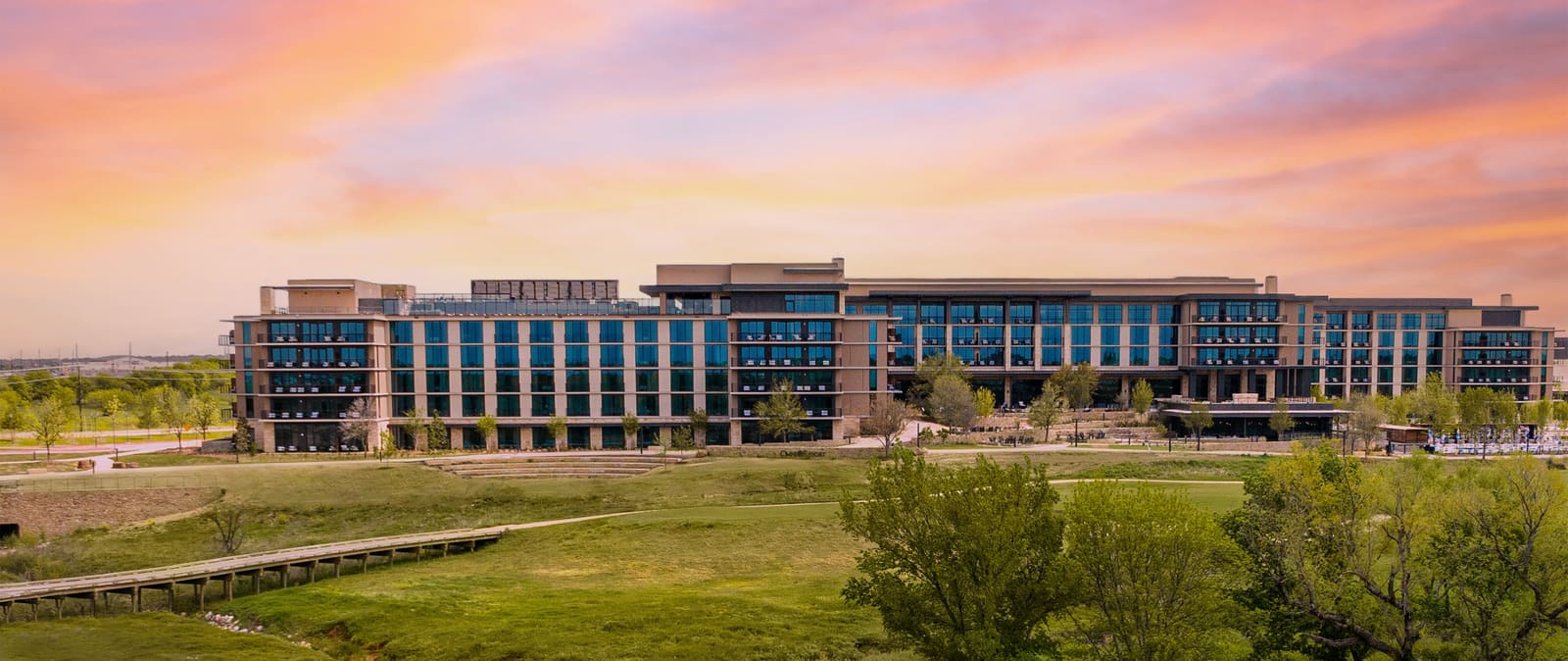 Resort exterior at sunset above the golf course and amphitheater lawn