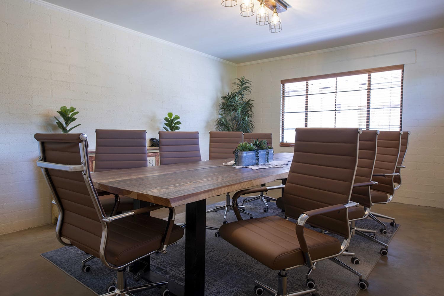 Executive boardroom with a long wood table and leather chairs