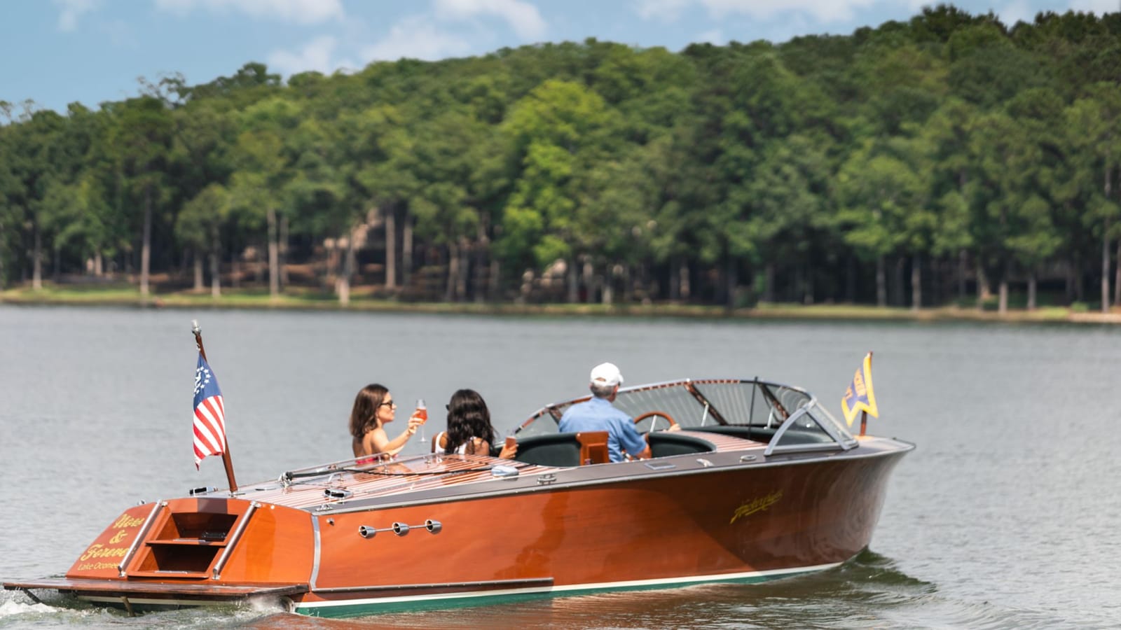 A classic wooden motorboat cruising on a lake