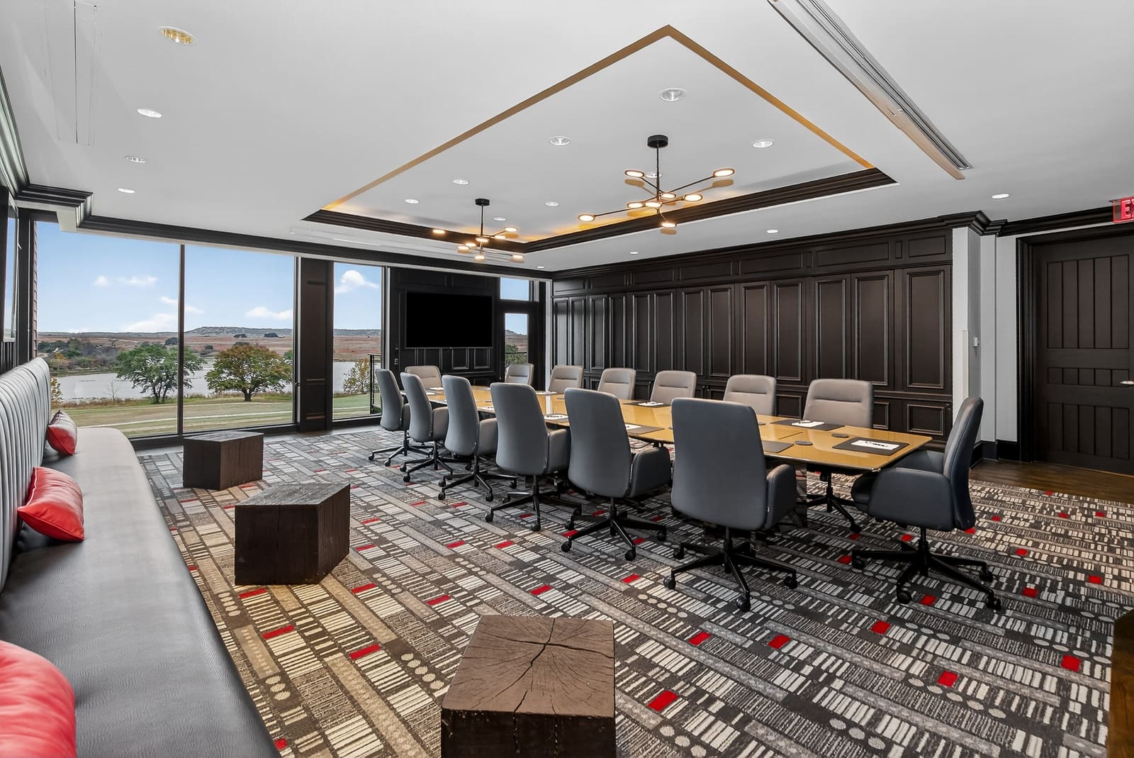 Boardroom with a long table and floor-to-ceiling windows looking out over the ranch and lake