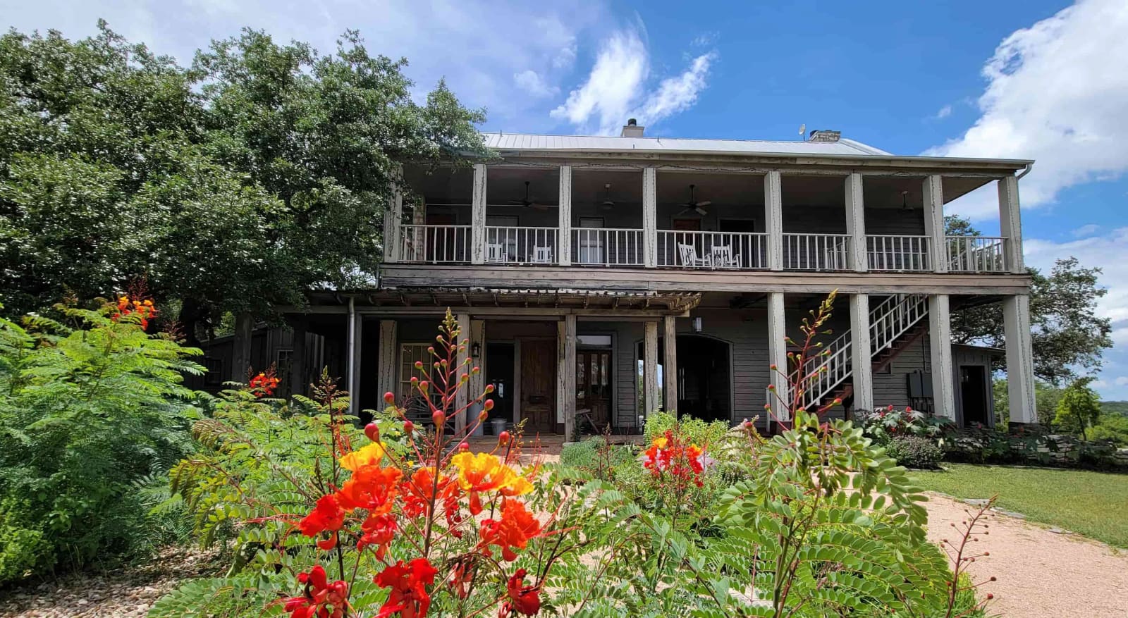 Two-story main inn with wraparound porches and gardens