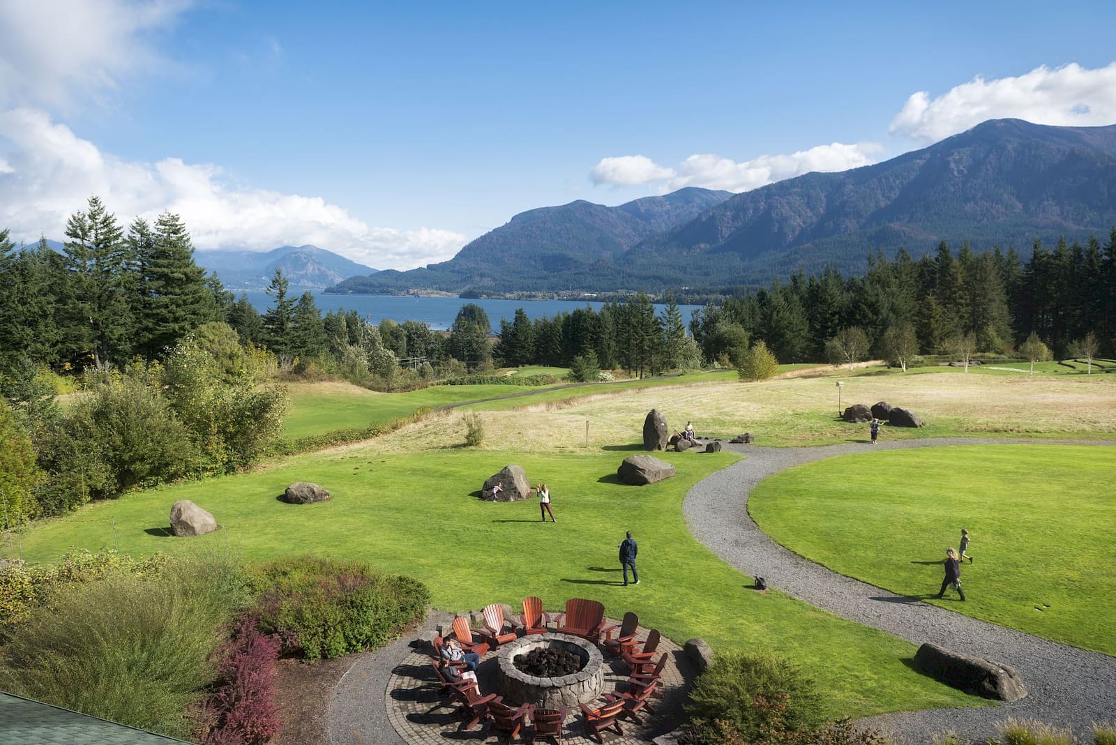 Lawn and fire pit below the lodge with the Columbia River and Cascade peaks beyond