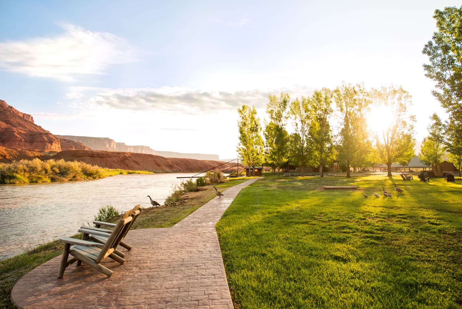 Riverside path and lawn along the Colorado River with red cliffs