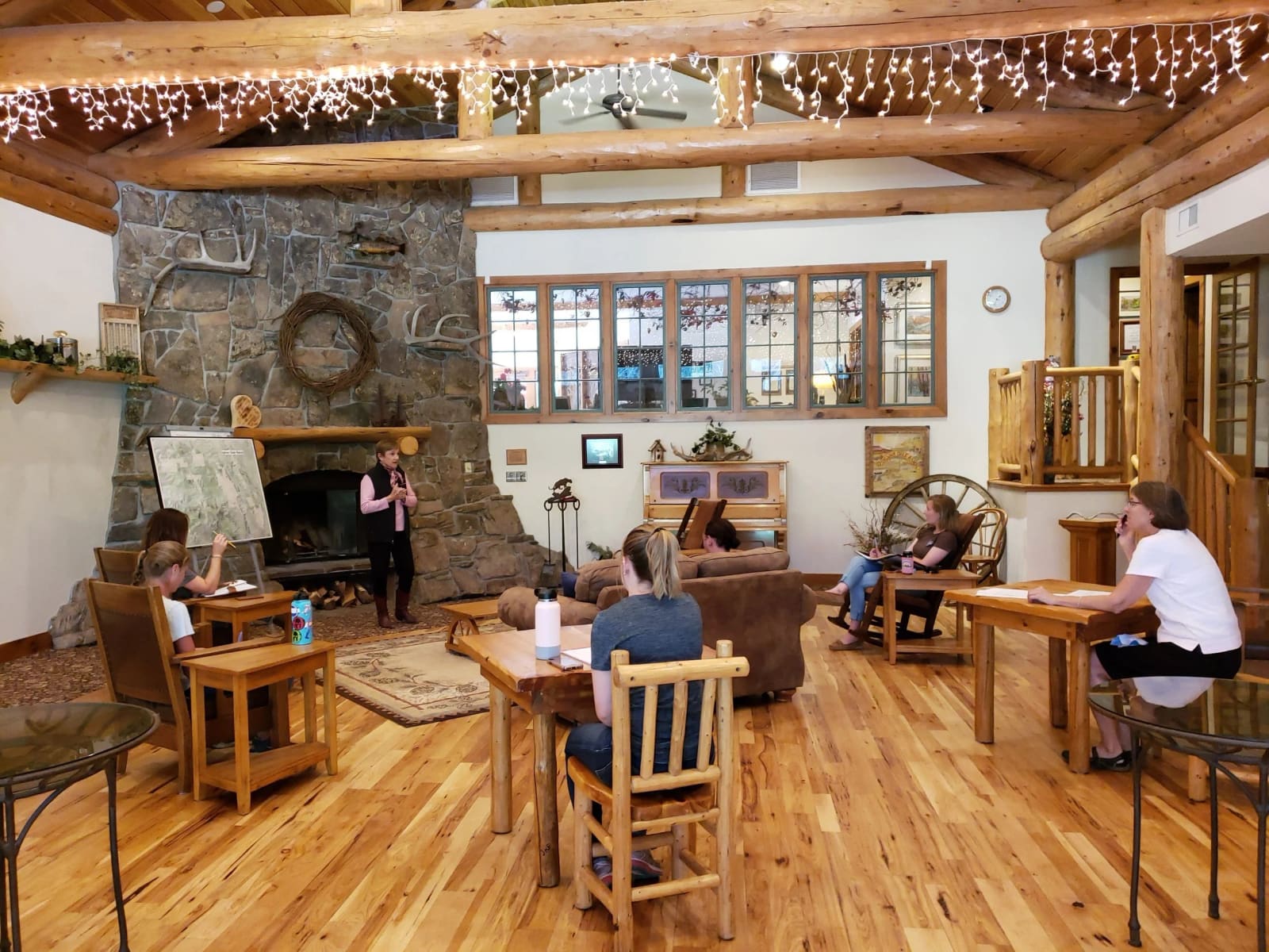 Inside the lodge with a stone fireplace and wood tables