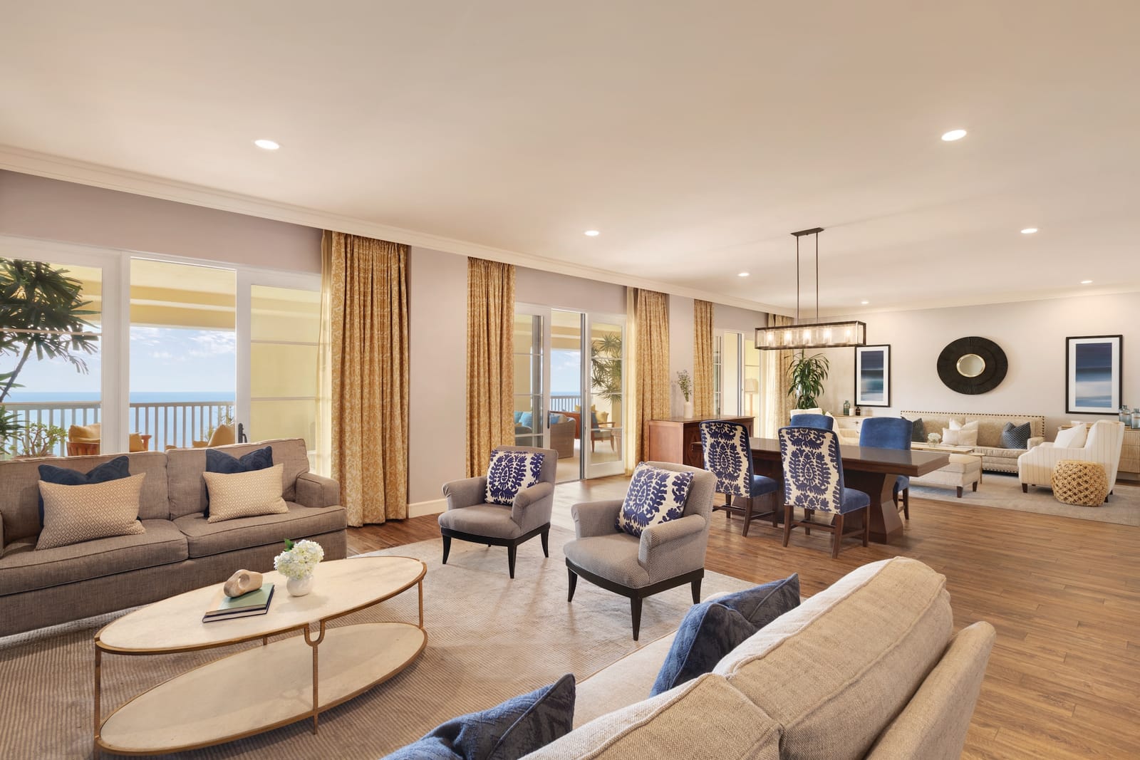 A meeting suite with sofas, a long table and tall windows