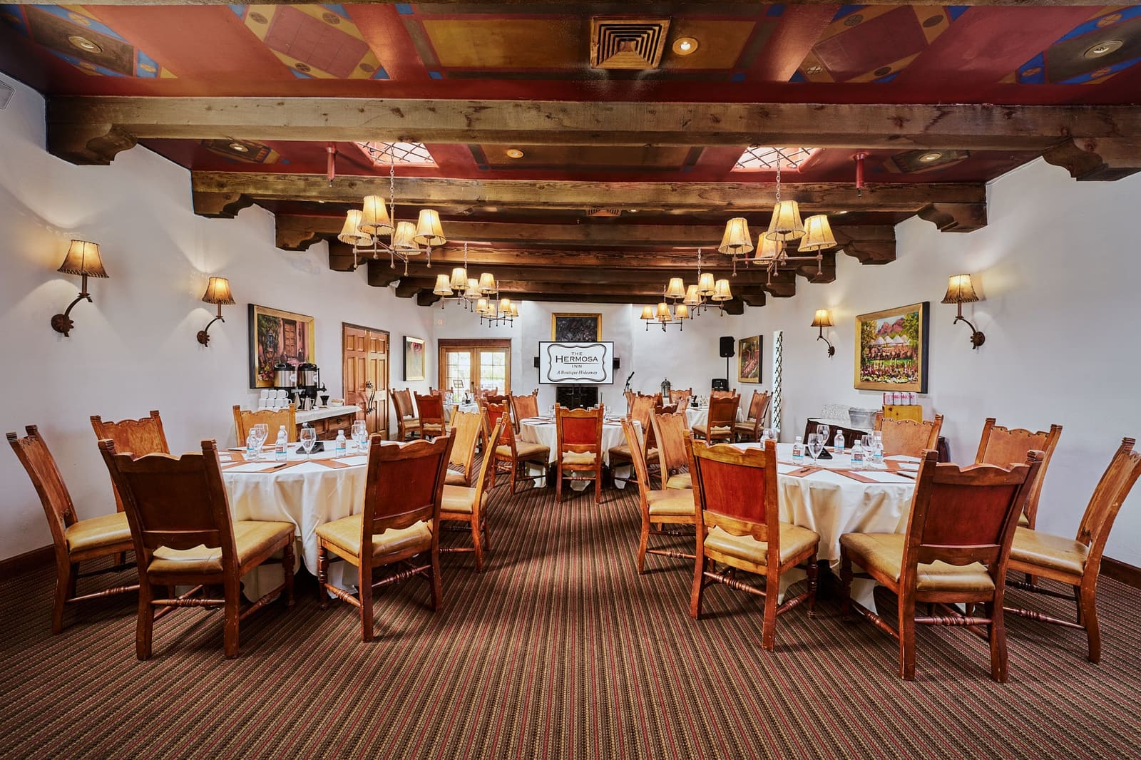 Stetson Room set with round tables under painted wood beams