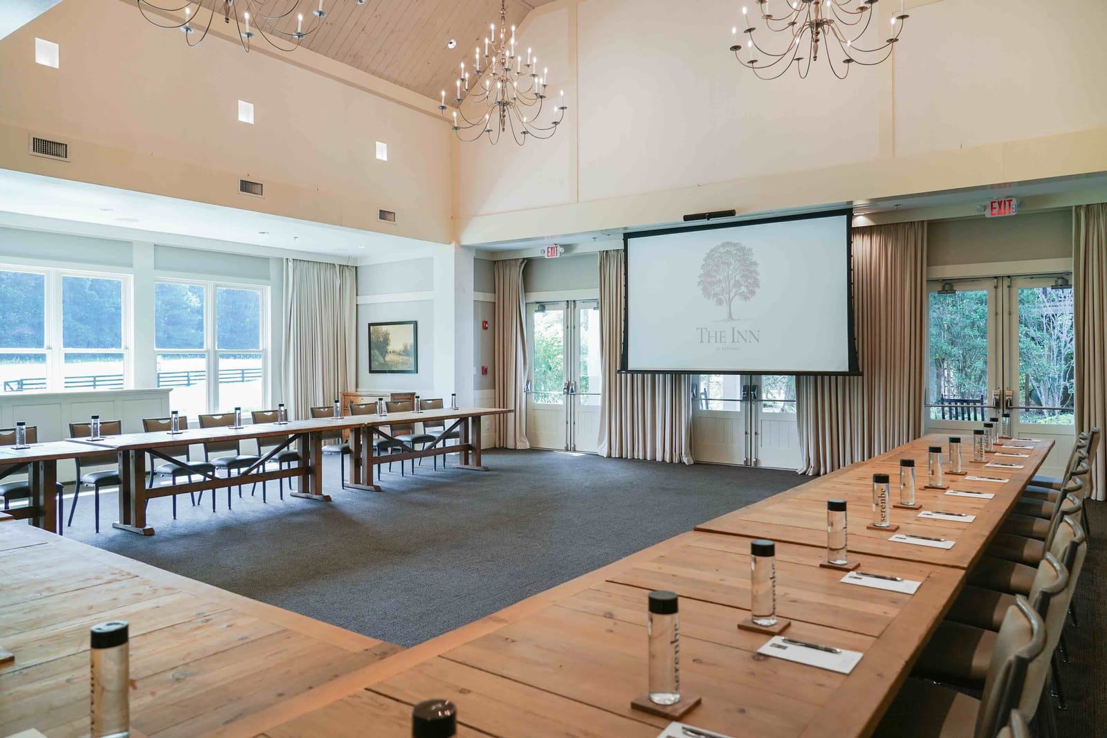 A bright meeting room with a U-shaped table and screens