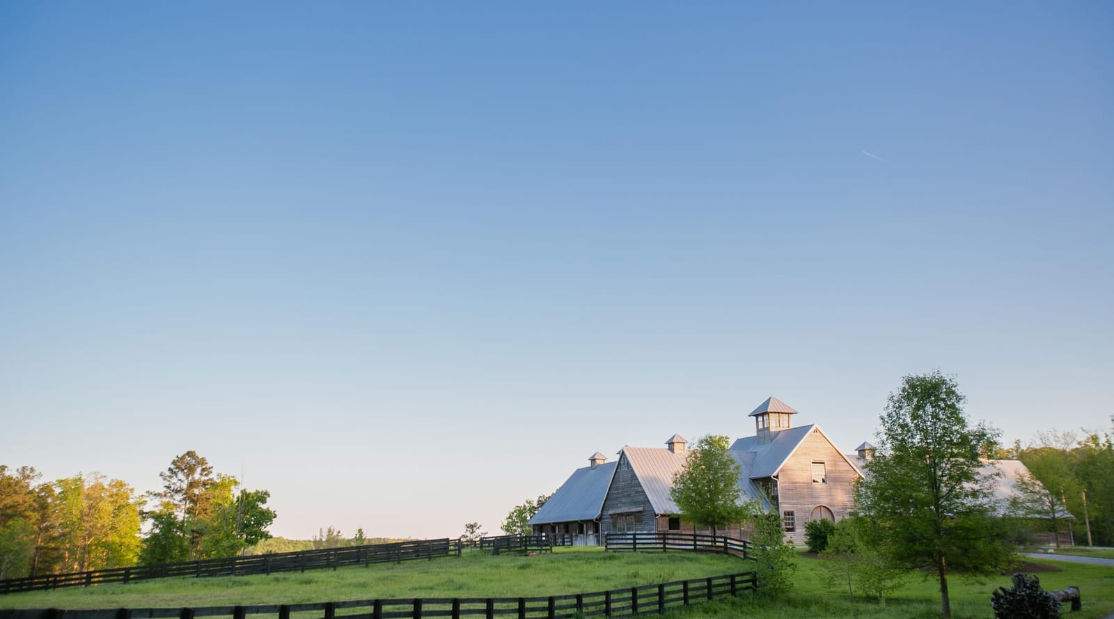 Farm barns in an open meadow at golden hour
