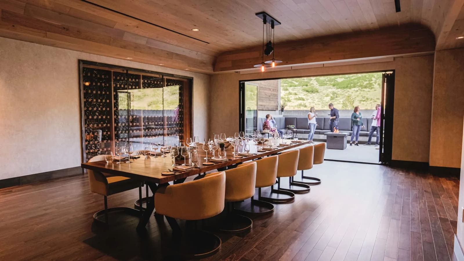 The Wine Room set with a long table, glass doors open to a mountain terrace