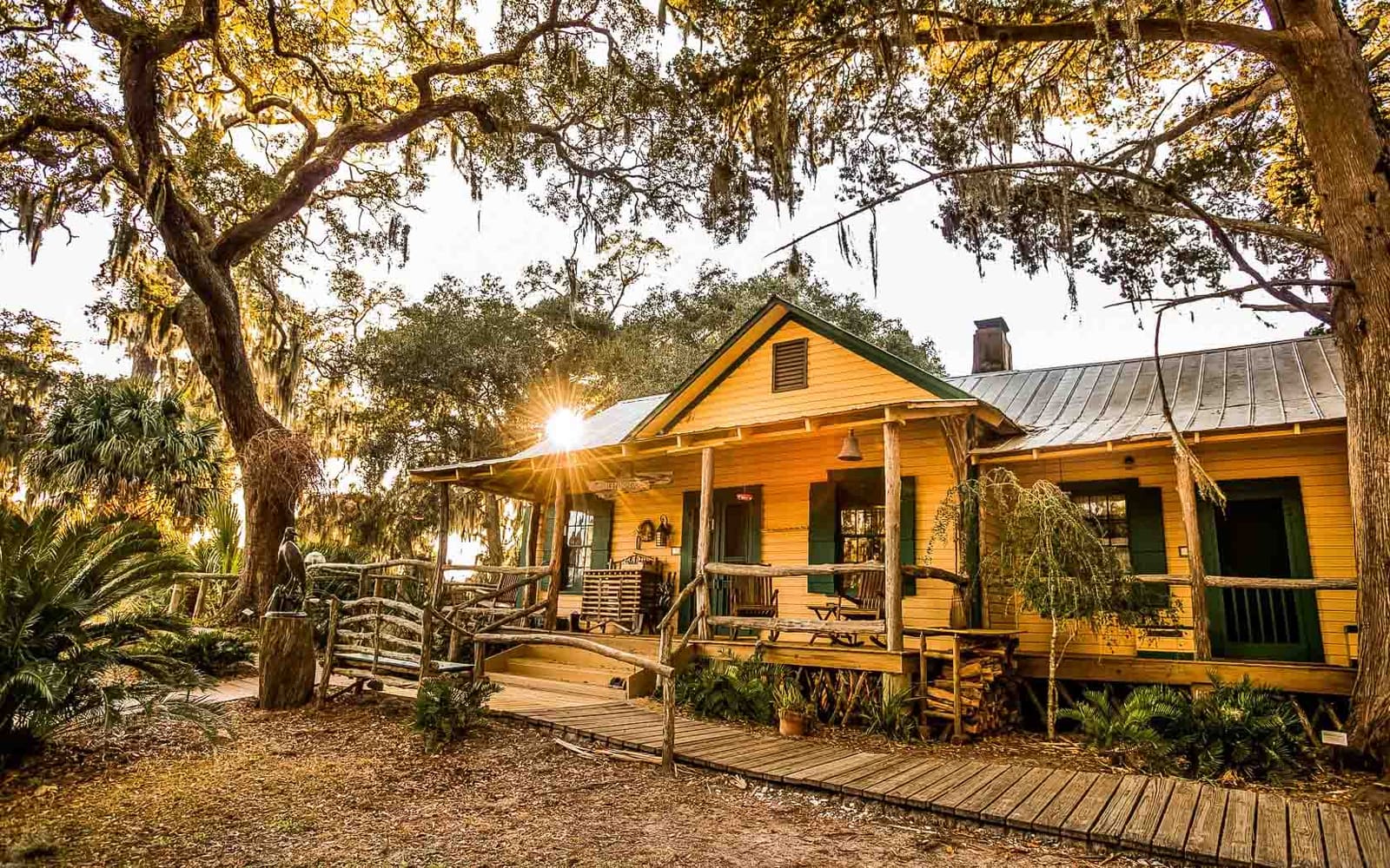 Exterior of the yellow lodge under the live oaks