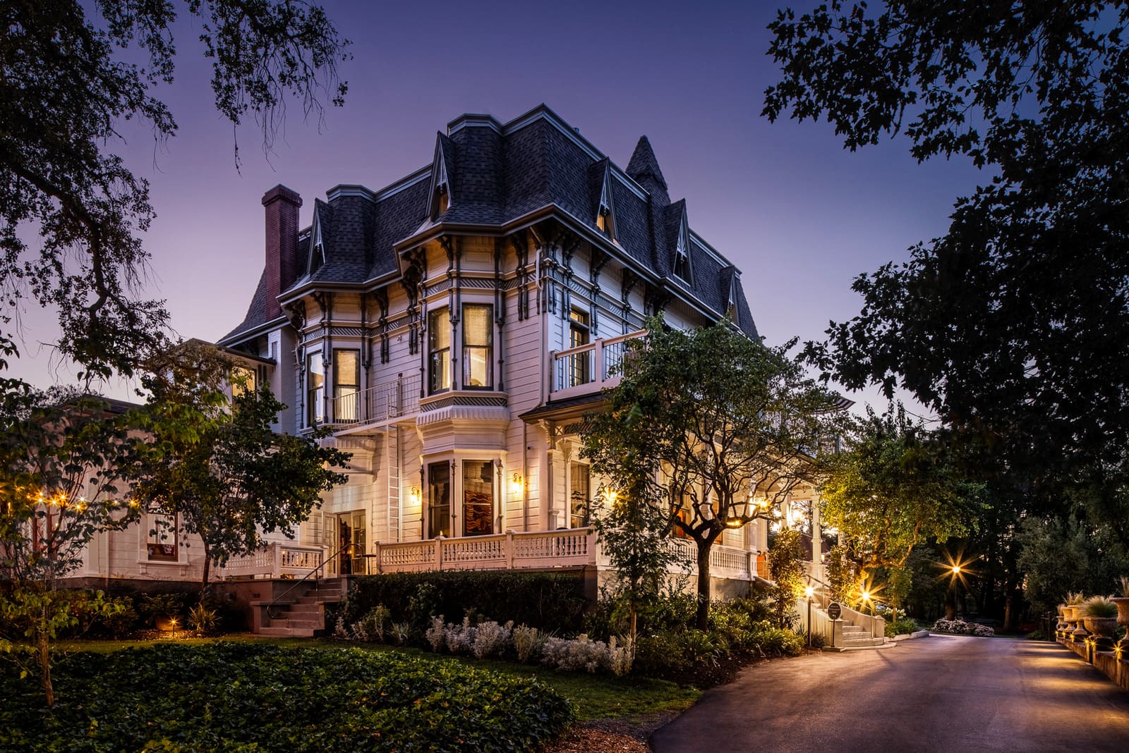 The Victorian mansion lit up at twilight