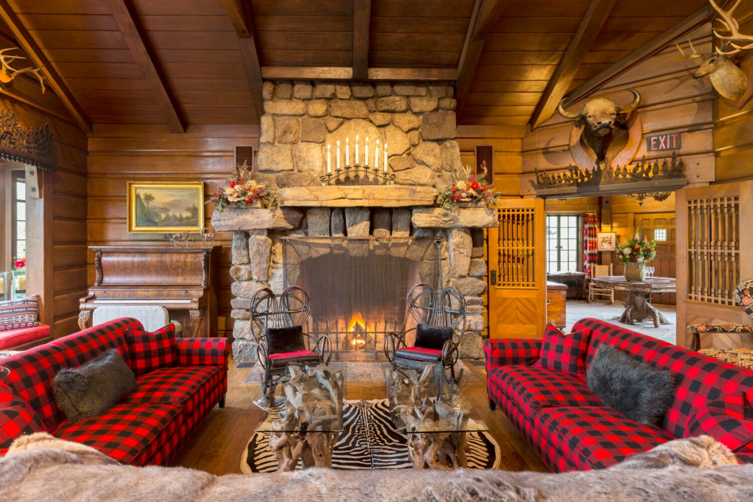 Log-walled Great Hall with a stone fireplace and sofas