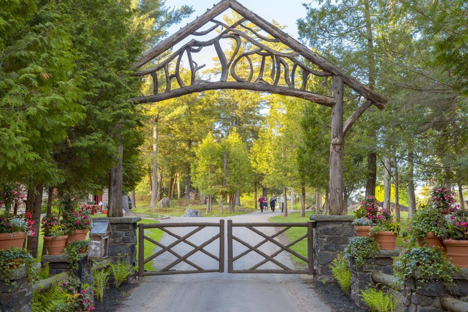 Rustic twig-arch entrance gate to The Point under tall pines